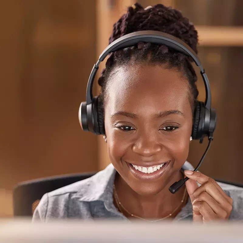  A woman with a headset, smiling brightly.