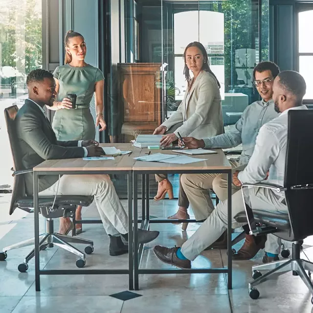 A group of salespeople sit around a table, engrossed in meaningful conversations and collective decision-making.