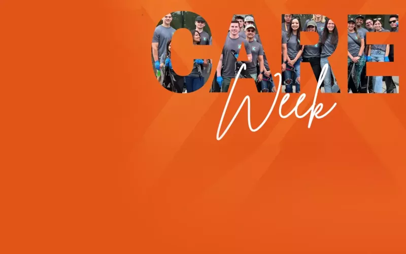 orange box with a group of people smiling at camera doing charity work