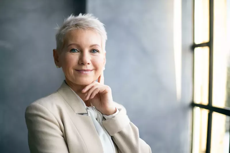 White-haired woman in a business suit exuding confidence.