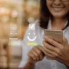 Young woman wearing glasses smiles are her smart phone. An overlay of frown, neutral and smile graphics show a highlight smile with a check mark.
